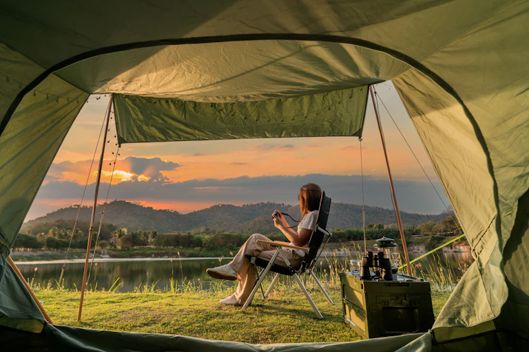 Woman sits outside her tent