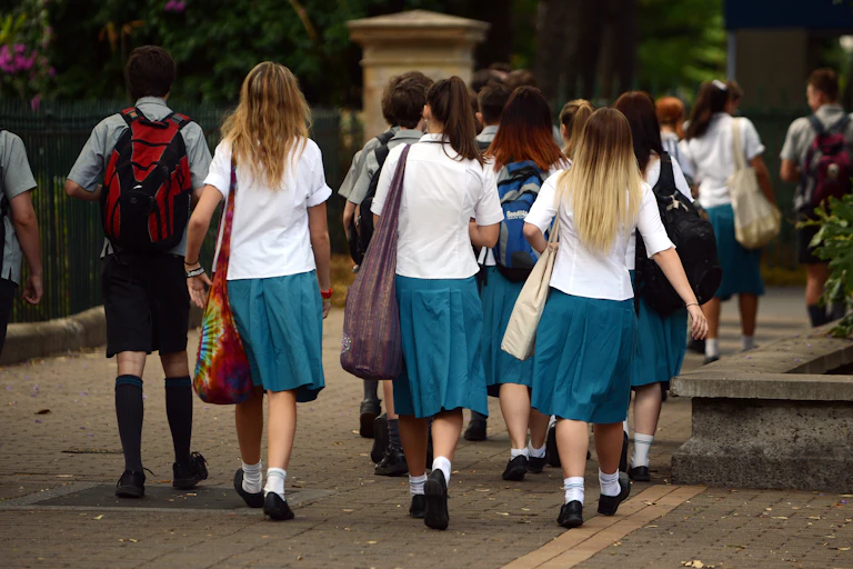 High school students walk along the pavement in a group.