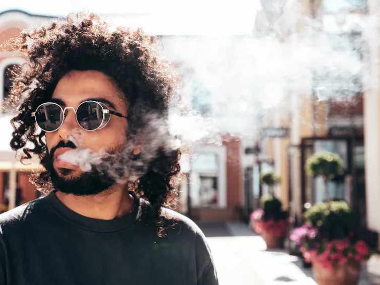 Man blowing out vape vapour