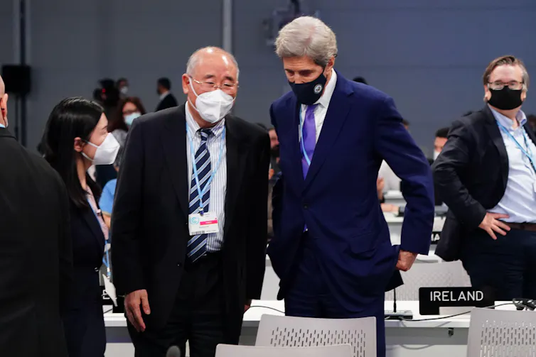 Two men in masks talking