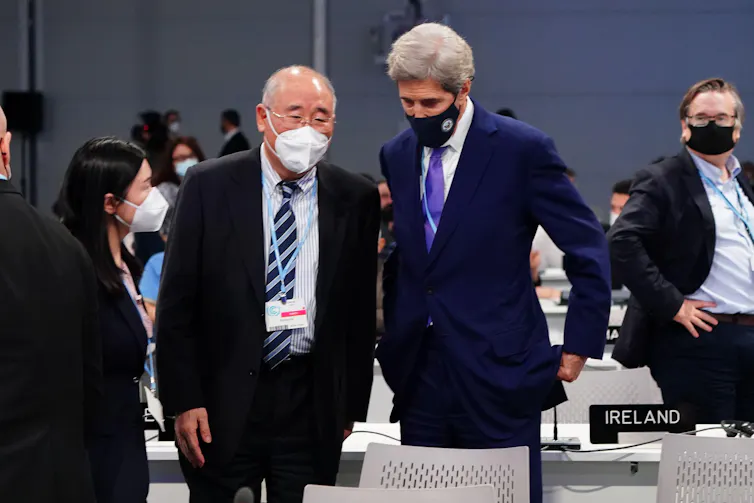 Two men in masks talking