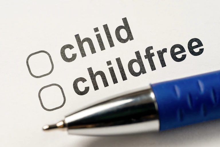 A pen resting on a piece of paper with two checkboxes, one for a child or childfree.