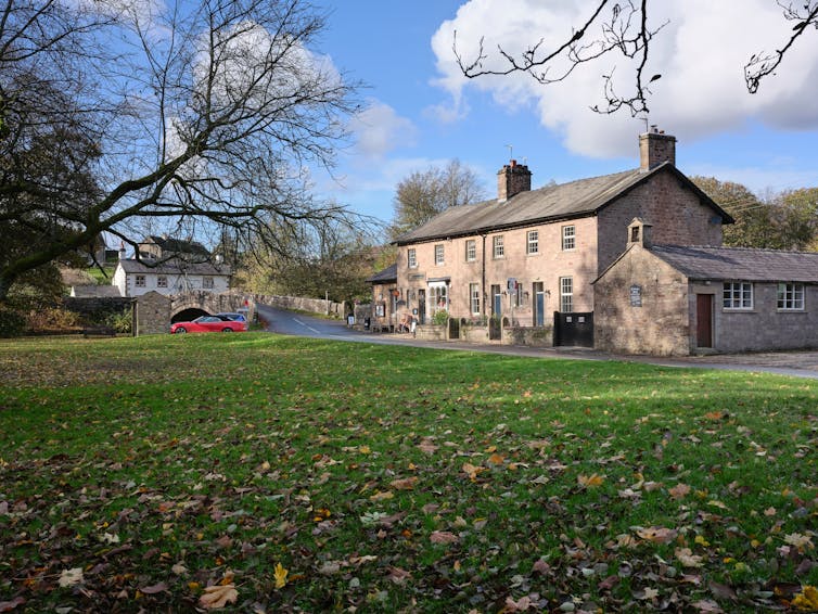A row of houses in a northern English village next to a bridge.