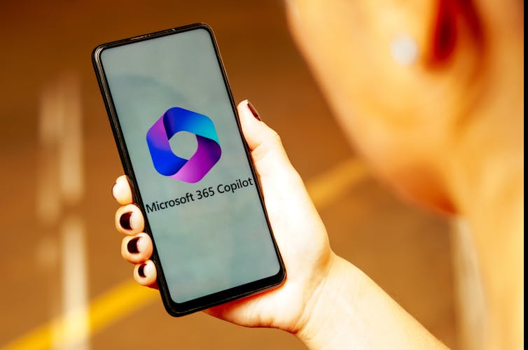 The Microsoft 365 Copilot logo is displayed on a smartphone screen held in a hand.