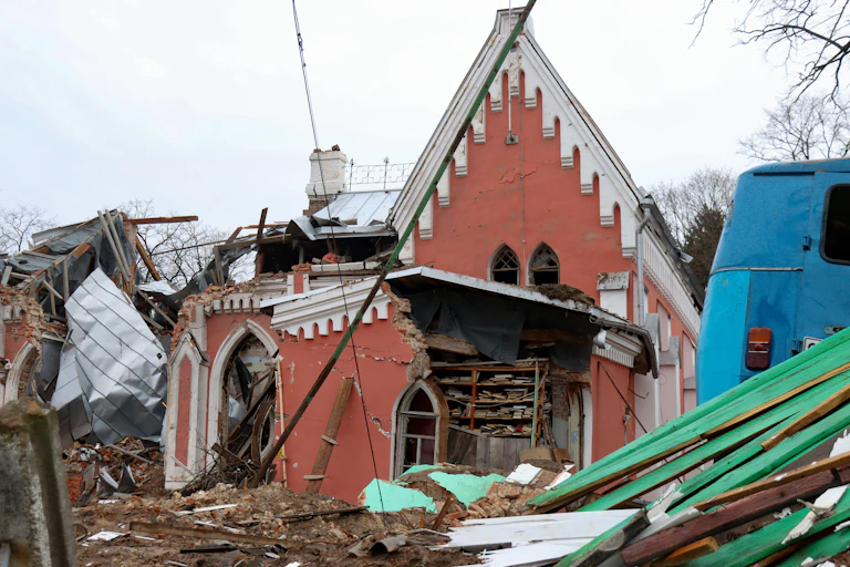 A red building with white roof destroyed by bombing.