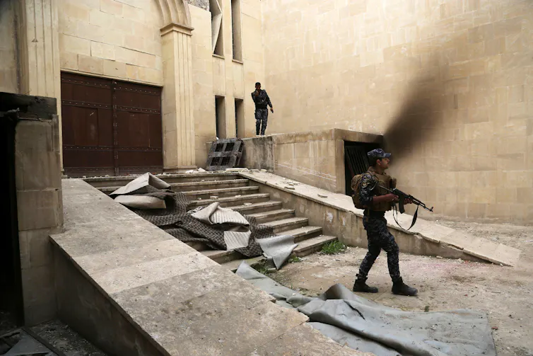 Police officers guarding a damaged building, Mosul museum, Iraq.