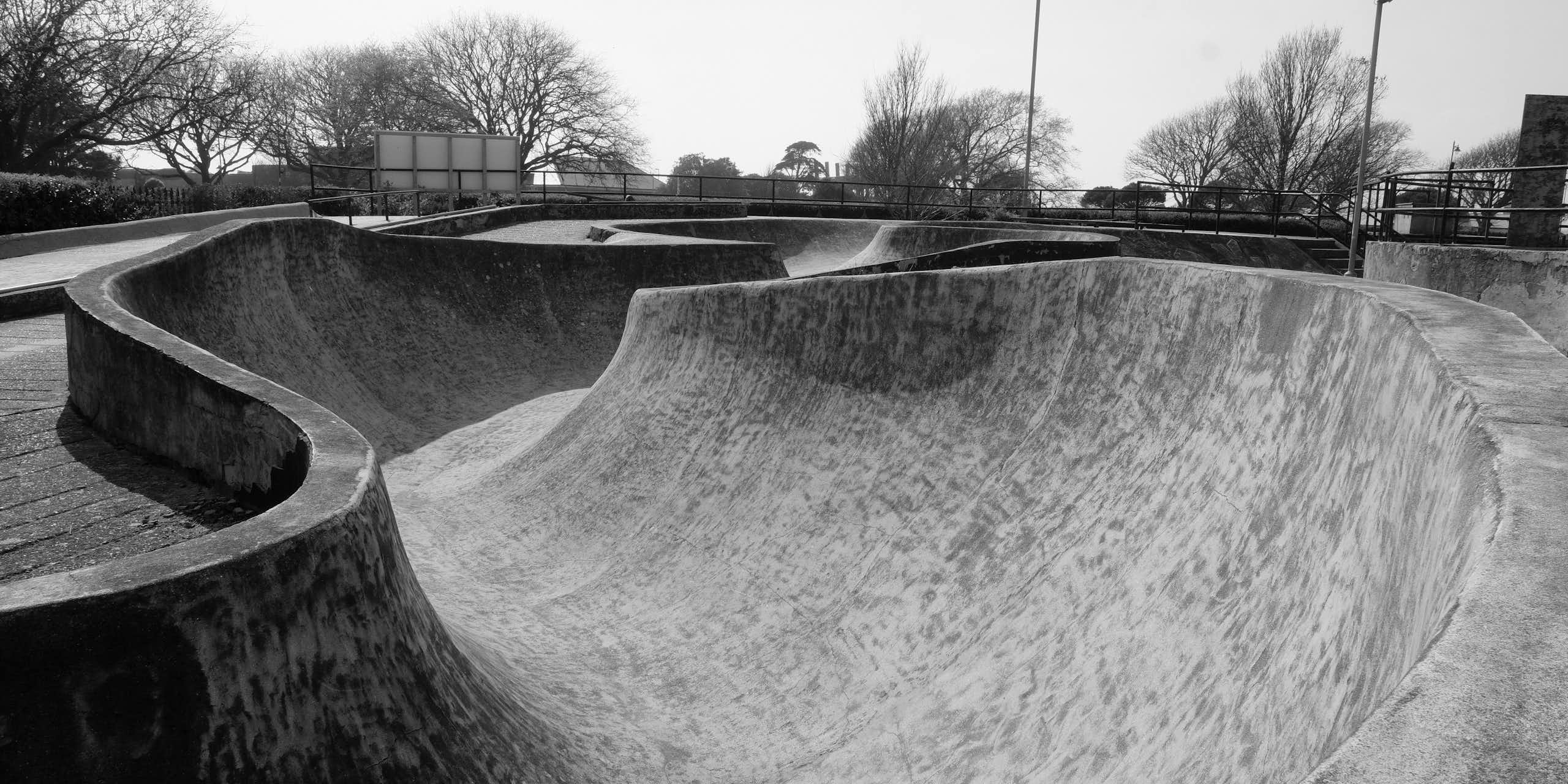 A black and white photograph of a skatepark.