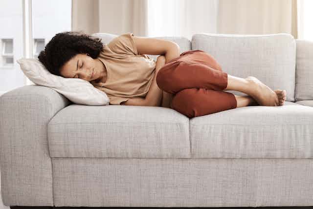 A woman with abdominal pain on a sofa