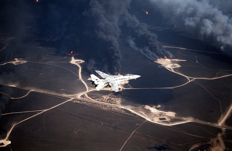 Aircraft flies over oil wells set ablaze by Iraqi forces.