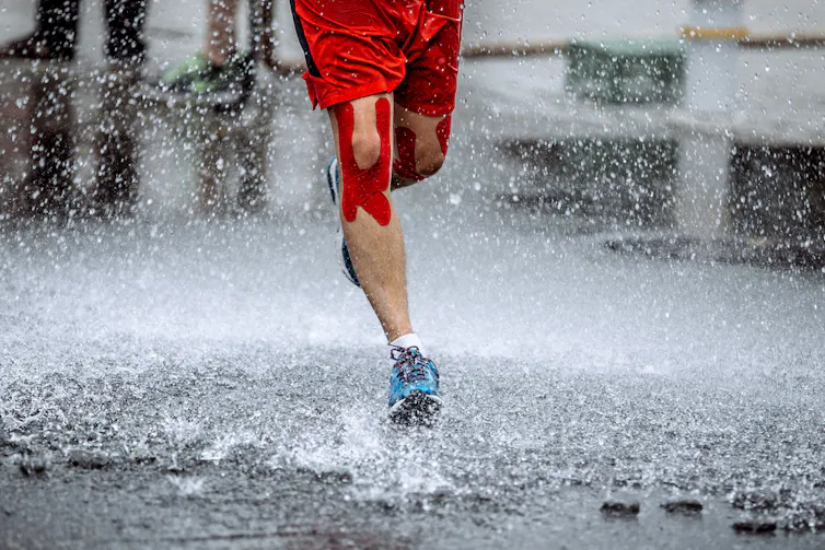 A runner with Kinesio tape on his legs.