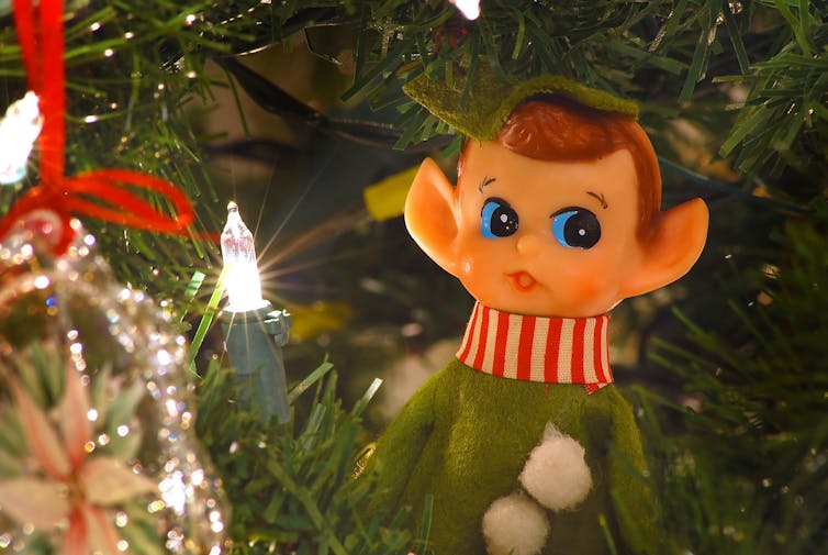 An elf ornament and Christmas light.
