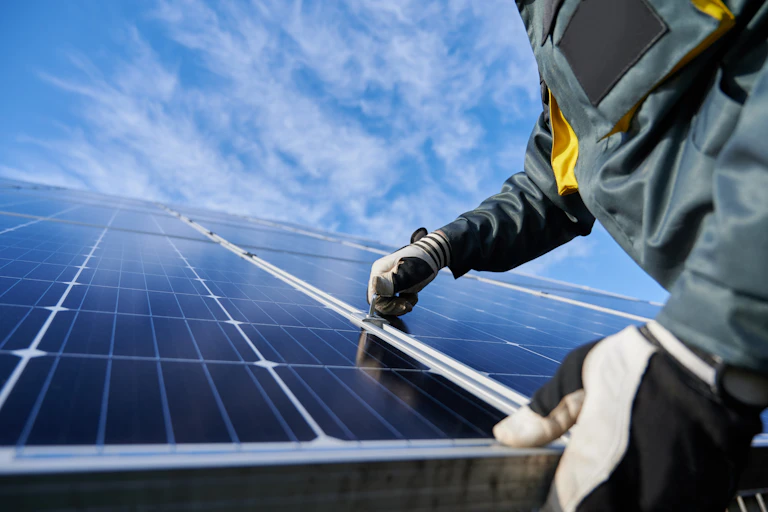 mãos com luvas seguram painéis solares