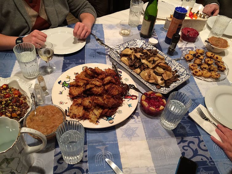 A table with a blue and white tablecloth, set with several serving dishes of fried foods.