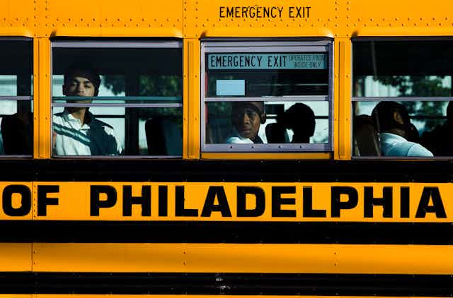 A close shot of a Philadelphia yellow school bus, with several students seen inside
