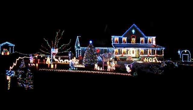 A suburban house and garden filled with very bright Christmas lights