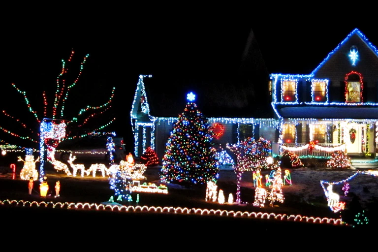 A suburban house and garden filled with very bright Christmas lights