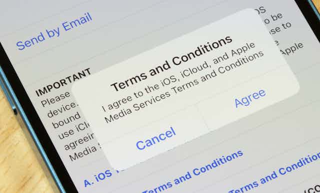 Image of an iPhone with a ''terms and conditions'' dialogue box displayed on the screen