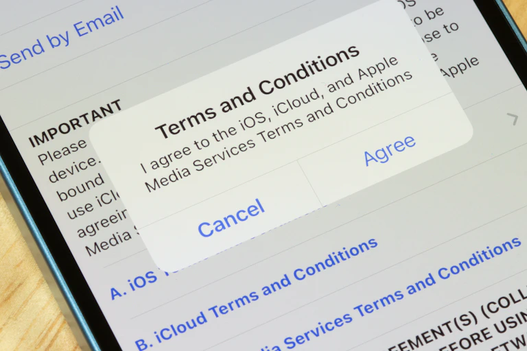 Image of an iPhone with a ''terms and conditions'' dialogue box displayed on the screen