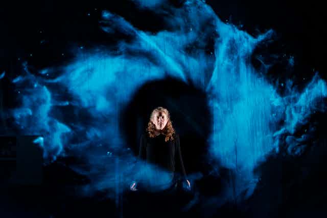 A woman in a blue swirl of light.