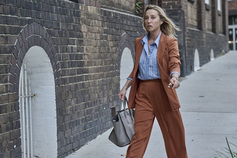 Asher Keddie in a brown suit.