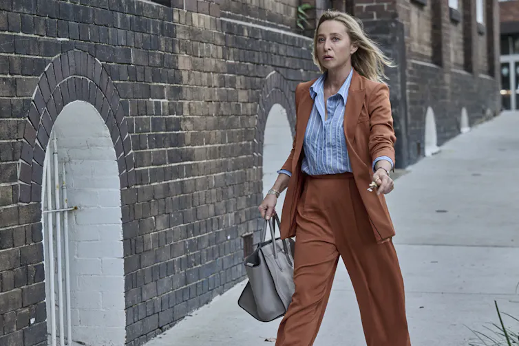 Asher Keddie in a brown suit.