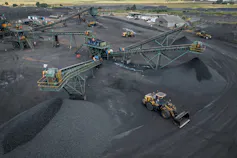 A coal mine on a large area of land covered with coal, coal dust and machines