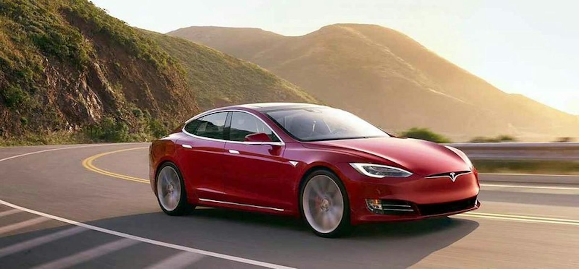 Une Tesla roule sur une route côtière