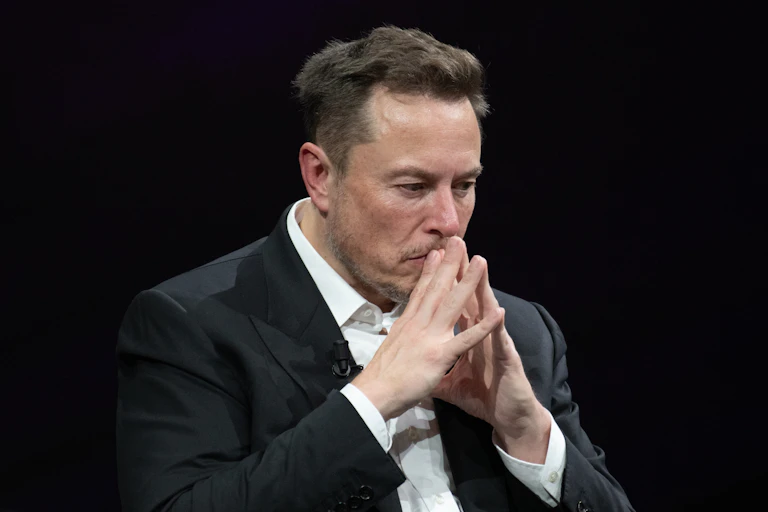 Elon Musk in front of a black screen.