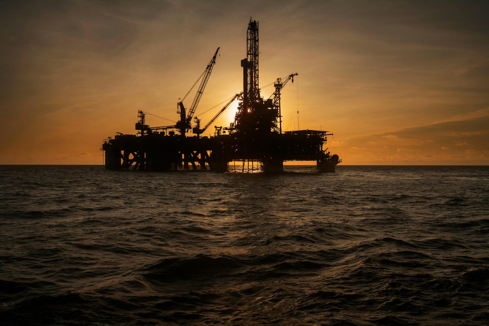 An offshore oil rig at sunset.