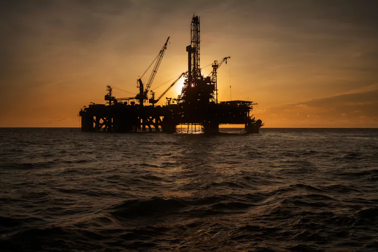 An offshore oil rig at sunset.