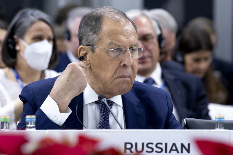 Russia's foreign minister, Sergei Lavrov, scowls as he adjusts his earpiece at the ister, Sergei Lavrov, at the OSCE ministers' meeting in North Macedonia on November 30.