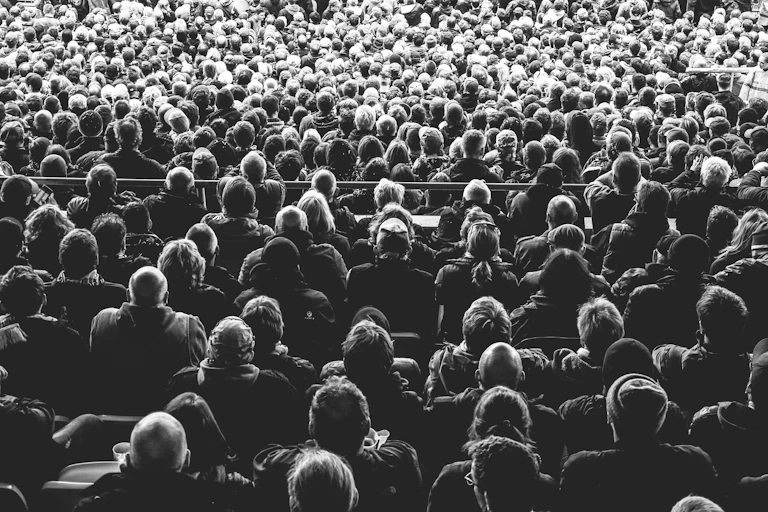 black and white photo from the back of seated baseball fans in stands