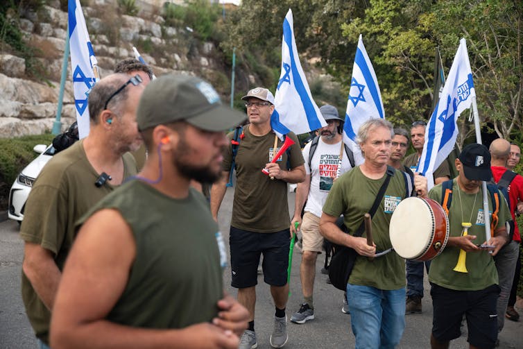People stand in a group holding Israeli flags.