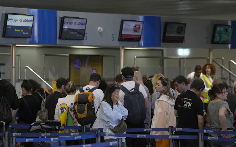 People stand in a line at an airport.