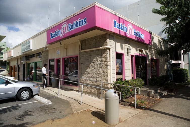 A Baskin-Robbins shop in a strip mall with its trademark pink branding.