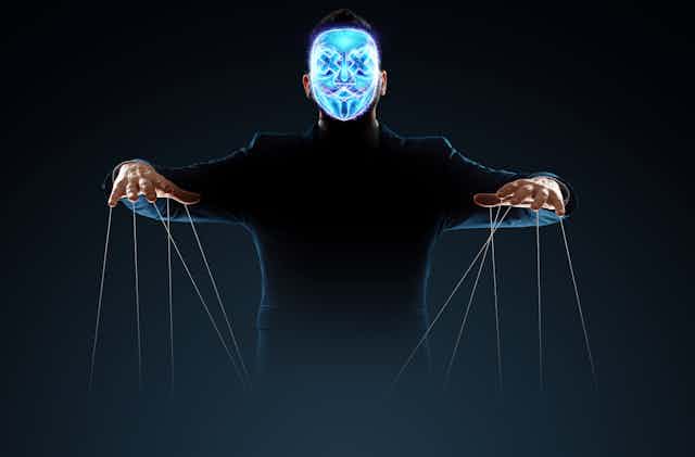 Man with blue holographic face with puppet strings hanging from hands