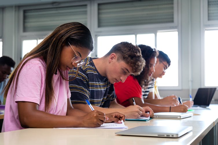 Students seated at desks writing tests.