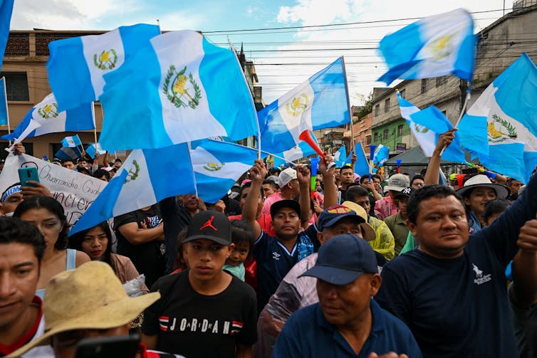 Crowd of protesters waving Guatemala flag