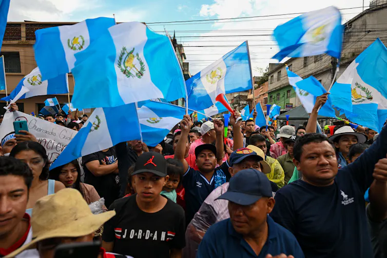 Crowd of protesters waving Guatemala flag