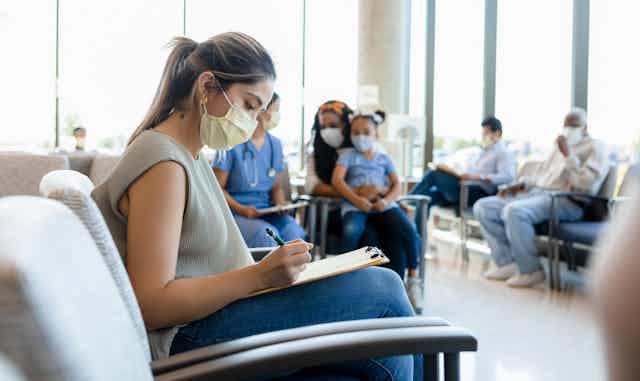 Woman fills in form at hospital waiting room