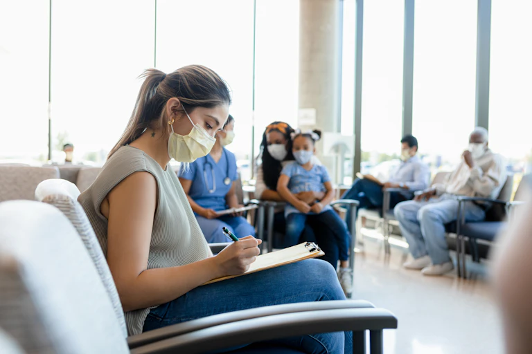 Woman fills in form at hospital waiting room