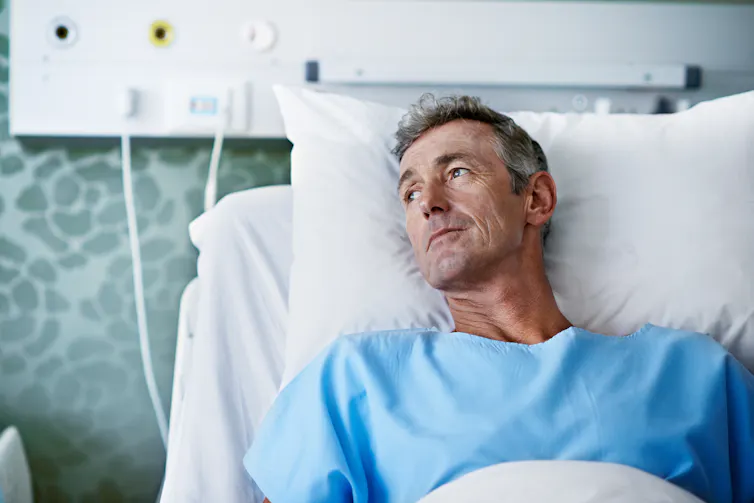 Man lays in hospital bed