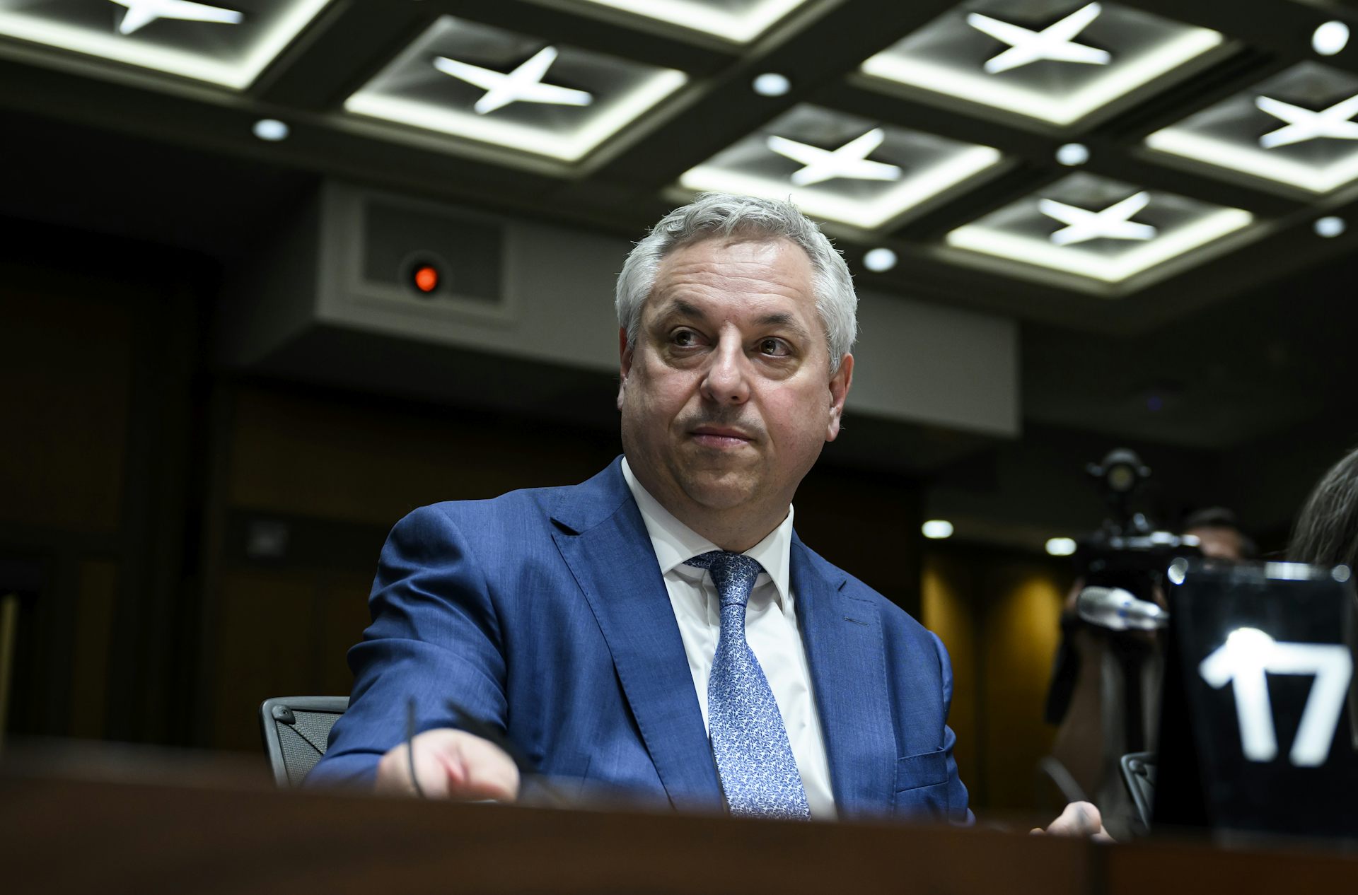 A man in a blue suit sitting at a table.