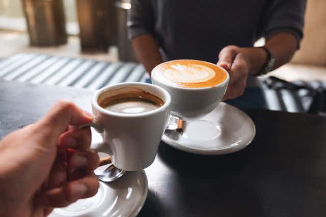 Hands holding cups of coffee