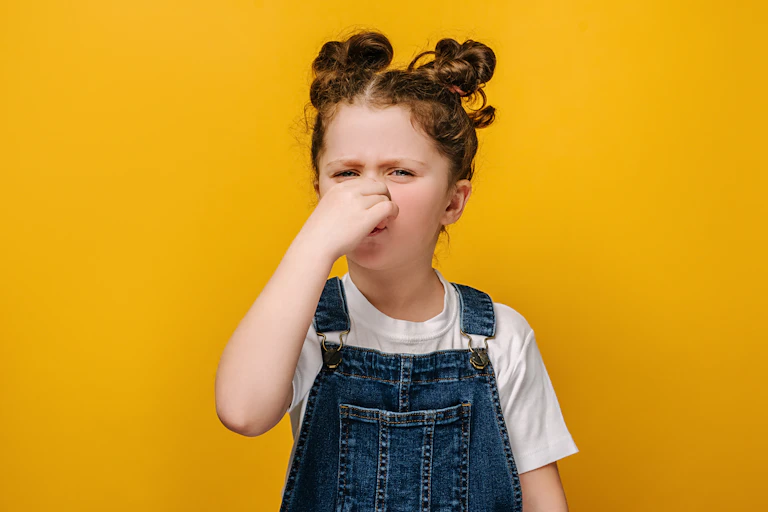 Girl holds nose