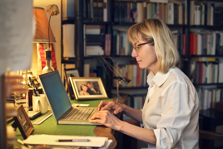 A woman works at her computer at home.