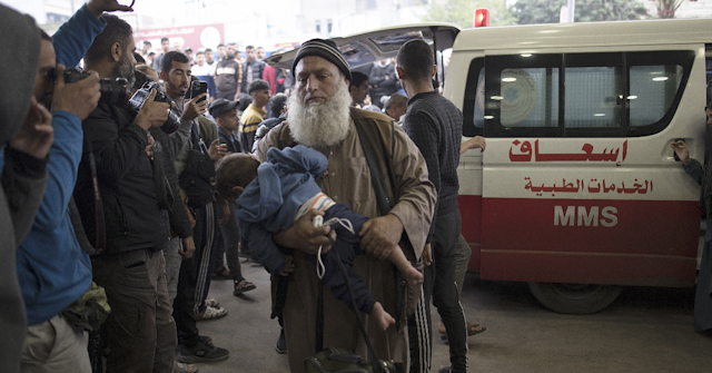 An elderly man walks away from an ambulance at a crowded hospital in Gaza.