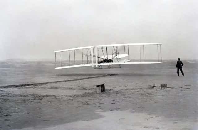 Wright brothers at moment of historic first flight at Kitty Hawk