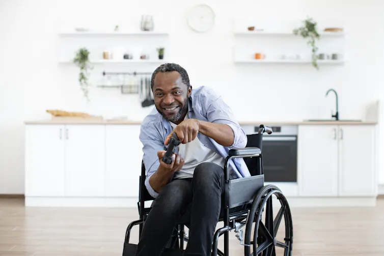 a man in a wheelchair with a game controller