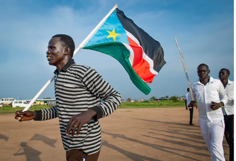 Homme transportant un drapeau du Soudan du Sud
